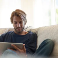 Man sitting on a sofa using his tablet